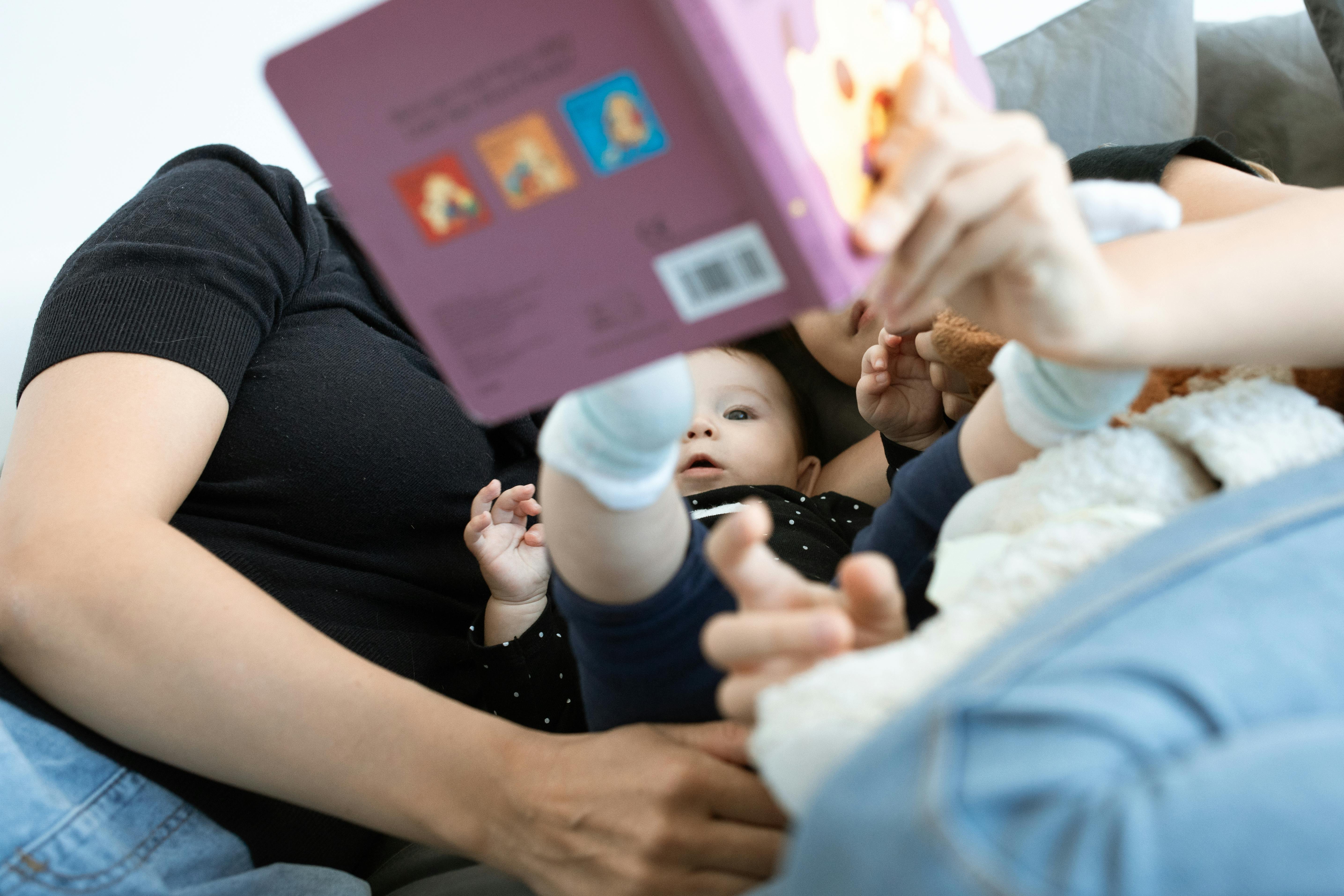 A parent reading a children book to their baby